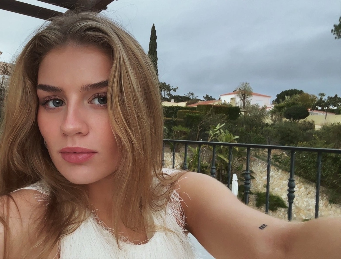 Rachel on a terrace with hills and houses behind her